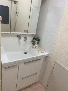 a white bathroom with a sink and a mirror at 日式庭院豪宅 
