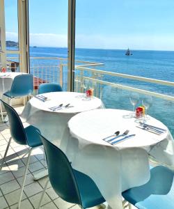 2 mesas y sillas con vistas al océano en Nina B&B, en Giardini Naxos