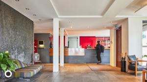 a man standing in a lobby with a bar at Center Hotels Arnarhvoll in Reykjavík