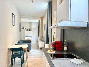a kitchen and living room with a counter and a table at Suite Orphelins 2 (rdc) in Reims