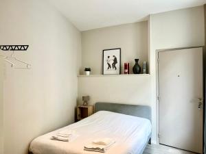 a bedroom with a bed with white sheets at Suite Orphelins 2 (rdc) in Reims