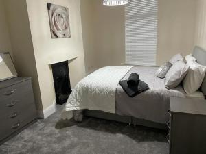 a bedroom with a bed with a hat on it at Lighthouse View - Lovely 3 bed 1st floor apartment in Fleetwood