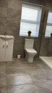 a bathroom with a toilet and a sink and a window at Lighthouse View - Lovely 3 bed 1st floor apartment in Fleetwood