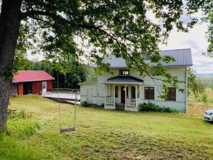 a white house with a porch and a yard at Hassela Villa in Hassela