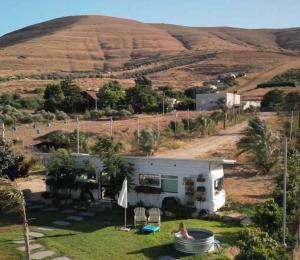 an rv parked in a field next to a hill at Leobus-לאו באס in Menaẖemya