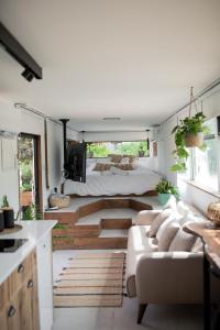 a living room with a couch and a bed in a room at Leobus-לאו באס in Menaẖemya