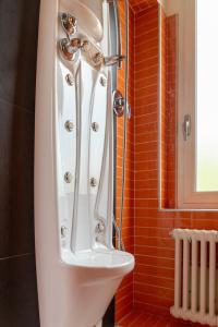 uma casa de banho com um chuveiro e um lavatório branco em Maison Cècile Appartamento in villa. Host Marianna em Agliè