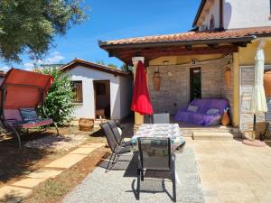a patio with a table and chairs and a house at Rustic house with private Pool in Šišan