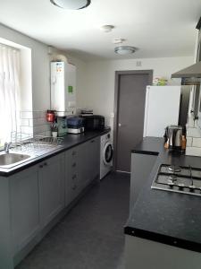 a kitchen with a sink and a stove top oven at 9 Dial Street in Liverpool