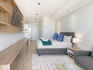 ein Schlafzimmer mit einem Bett und ein Wohnzimmer mit einem Sofa in der Unterkunft Ellipse Waterfall 3902 in Midrand
