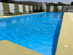 uma grande piscina azul com cadeiras num edifício em Casa Rural Humberto con 3 dormitorios em Málaga