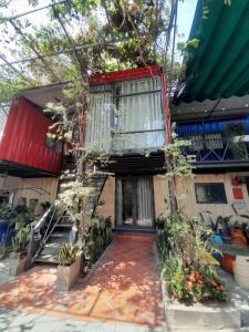 a house with a balcony and a staircase in front of it at H-HOMESTAY CONTAINER LAGI BEACH in La Gi