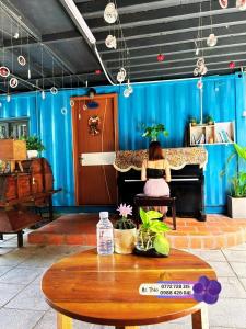 a girl sitting on a bench in front of a piano at H-HOMESTAY CONTAINER LAGI BEACH in Lagi