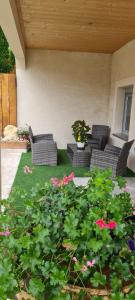 a patio with couches and flowers in a yard at LE NID DES PLANCHETTES - Suite Chambres d'Hôtes 