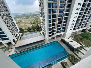 eine Luftansicht auf zwei hohe Gebäude und einen Pool in der Unterkunft Comfy Suite with Netflix At Setia Alam in Shah Alam
