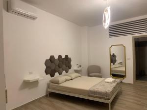 um quarto branco com uma cama e um espelho em Da Minguccio em Venosa