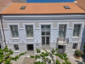 a white house with an orange roof at Zoe's Villa - Modern Karystos Apartments By The Port & Beach in Karistos