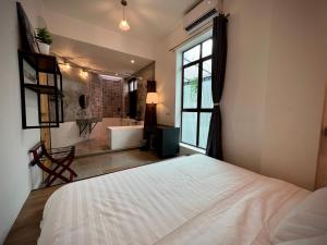 怡保的住宿－DoSomething Guest House 8，卧室配有床、浴缸和窗户。