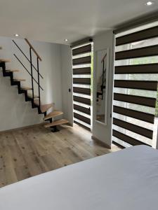 a bedroom with a staircase and a room with wooden floors at Trees Fontain in Jalhay