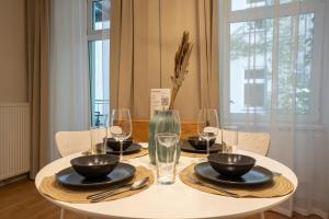 a white table with plates and bowls and glasses on it at 42 m2 central bright apartment with a terrace in Vienna