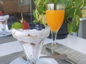uma mesa coberta com um copo de gelado e uma bebida em Leeuwenzee Guesthouse em Cidade do Cabo