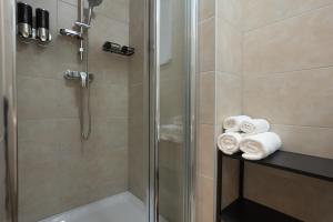 a bathroom with a shower and towels on a shelf at 42 m2 central bright apartment with a terrace in Vienna
