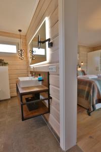 a bathroom with a sink and a bed in a room at Frei wie der Wind-Chalets in Dierhagen