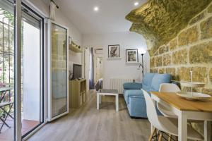 a living room with a blue couch and a table at Casas Rurales El Tajo in Setenil