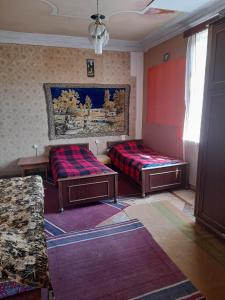 uma sala de estar com duas camas e um sofá em individual low-budget guest-house em Tsqaltubo