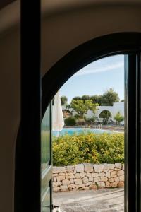 a view of a swimming pool through a window at Masseria Gorgognolo in Ostuni
