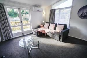 sala de estar con sofá y mesa de cristal en The Hidden Gem - tranquility close to town, en Wellington