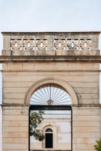 a building with an arch with a window at Masseria Gorgognolo in Ostuni