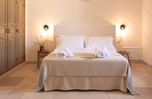 a bedroom with a bed with two towels on it at Masseria Gorgognolo in Ostuni