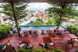 a patio with tables and chairs and a swimming pool at Silverland Yen Hotel in Ho Chi Minh City