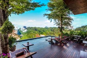 una terraza con mesas de madera, sillas y árboles en Silverland Yen Hotel en Ho Chi Minh