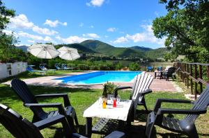 een tafel en stoelen voor het zwembad bij Agriturismo Gioie di Campagna in Fabriano