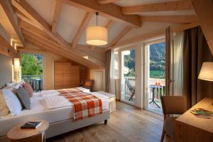 una camera con un letto in una stanza con finestre di Active Hotel Monte Giner a Mezzana