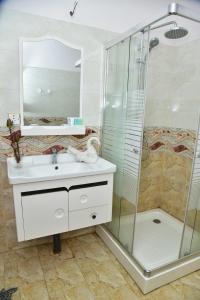 y baño con lavabo y ducha. en The New Crown Hotel, en Dambulla