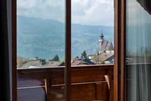 a window with a view of a town and a church at Kaisigen43 in Steinbach am Attersee