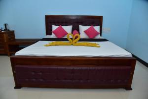 Una cama con dos arcos amarillos. en The New Crown Hotel, en Dambulla