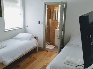 a bedroom with two beds and a door to a bathroom at Forest House Hotel in London