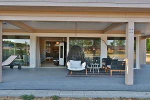 a house with a swing chair on a porch at Frei wie der Wind-Chalets in Dierhagen