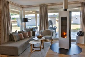 a living room with a couch and a fireplace at Frei wie der Wind-Chalets in Dierhagen