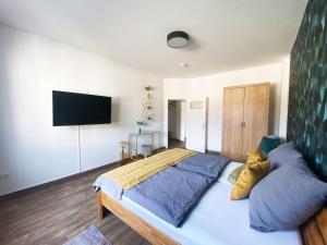 Loft Appartement في بيليفيلد: غرفة نوم بسرير كبير وتلفزيون بشاشة مسطحة