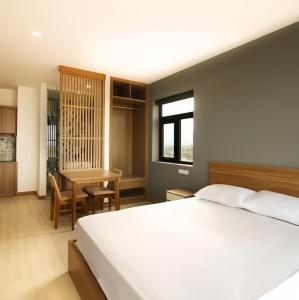 a bedroom with a bed and a desk and a table at LaLa Apartment and Hotel in Da Nang