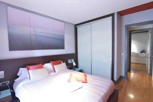 um quarto com uma grande cama branca com almofadas vermelhas em JUST-ROOM. Apartamento Javier em Santander