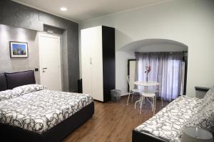 een hotelkamer met 2 bedden en een tafel bij Duomo Bed & Breakfast in Catania