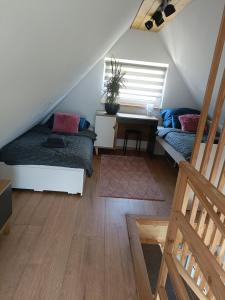 sypialnia na poddaszu z łóżkiem i biurkiem w obiekcie Domki w górach pod Szczyrkiem w Szczyrku