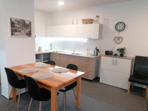 a kitchen with a wooden table and black chairs at Apartman 26 Mymara in Bešeňová