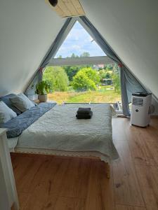 a bedroom with a bed and a large window at Domki w górach pod Szczyrkiem in Szczyrk
